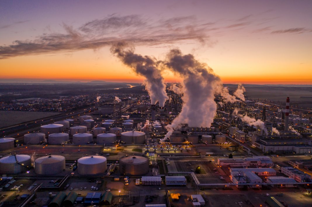 Aerial view of oil refinery at sunset. Drone point of view shot of an oil refinery under a moody sky at sunset.